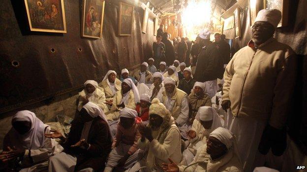 Christian pilgrims pray at the Church of the Nativity during Christmas celebrations in the West Bank biblical town of Bethlehem