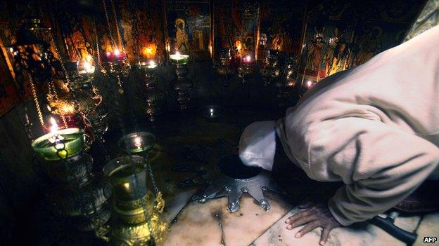 A Christian pilgrim prays inside the Grotto in the Church of the Nativity, traditionally believed to be the birthplace of Jesus Christ, during Christmas celebrations in the West Bank biblical town of Bethlehem