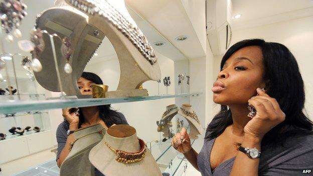 A customer tries a fashion accessory displayed for sale at Temple Muse in Lagos on June 14, 2013.