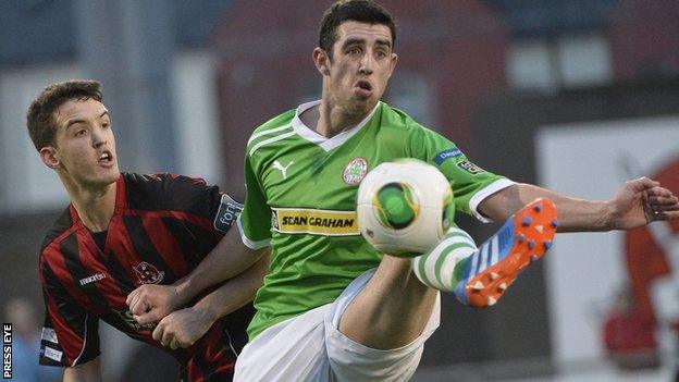 Josh Robinson of Crusaders in action against Cliftonville striker Joe Gormley