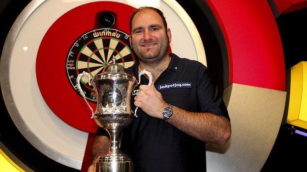 Scott Waites of England celebrates with the trophy after defeating Tony O'Shea of England in the final of the BDO Lakeside World Professional Darts Championships in 2013.