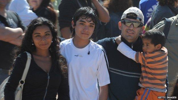 Chilean miner Alex Vega (right, holding a boy) arrives at the San Jose mine for a mass near Copiapo on 17 October, 2010