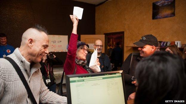 Lynne Johnston of Los Angeles, California celebrates after purchasing marijuana products at the 3-D Denver Discrete Dispensary 1 January 2014