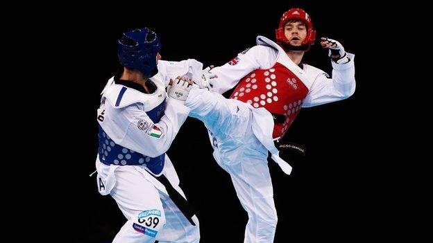 Aaron Cook of Great Britain (red) in action against Gianluca D'Alessandrio of Italy (blue) during the Taekwondo preliminary round at the London Prepares LOCOG Test Event for London 2012 at ExCel on December 4, 2011 in London, England.