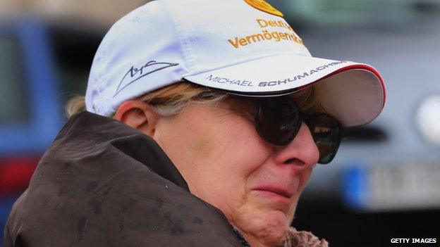 A woman cries as fans gather outside the Grenoble University Hospital Centre (3 Jan 2014)