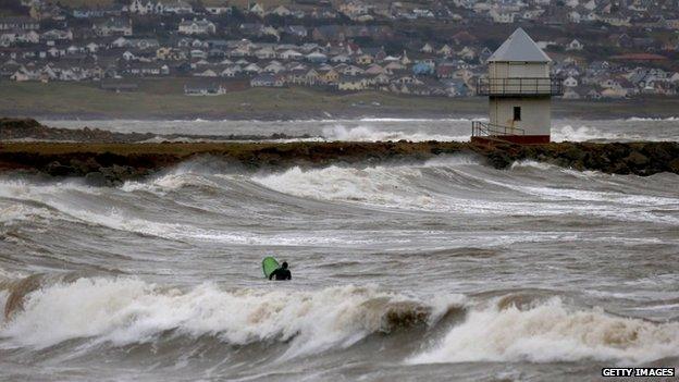 A surfer in rough waves at Porthcawl on Sunday