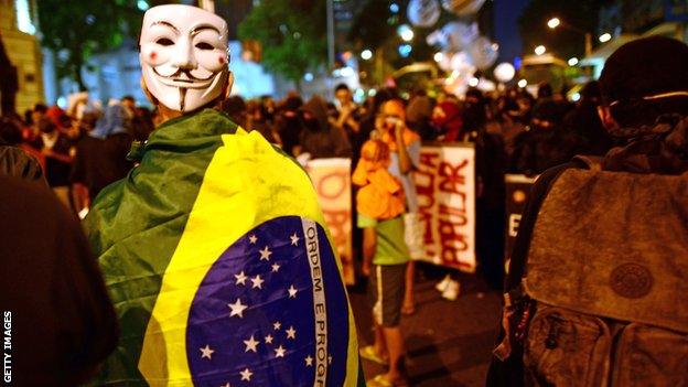 A demonstrator with a Guy Fawkes mask is pictured as clashes with the riot police erupt after a march by Brazilian workers in Rio de Janeiro on July 11, 2013 in a day of industrial action.