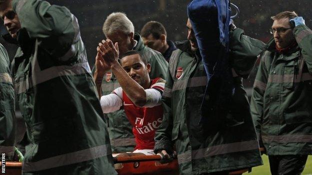 Theo Walcott is taken off on a stretcher