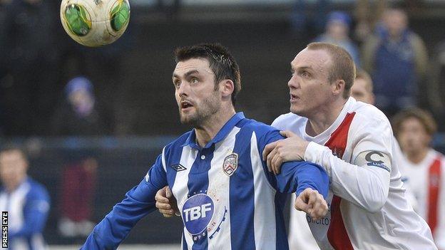 Coleraine striker Eoin Bradley shields the ball from Ards opponent Andy Hunter