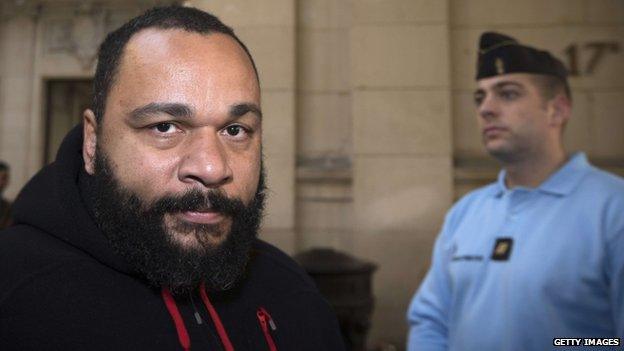 Dieudonne M'bala M'bala (L) arrives for his trial at the Paris courthouse on December 13