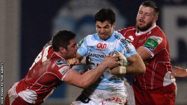 Mike Phillips of Racing Metro is tackled by Rob McCusker of Scarlets