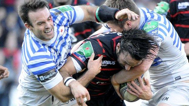 Saracens players Neil de Kock and Owen Farrell tackle Toulouse's Clement Poitrenaud