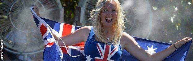 A spectator poses in front of water cooling fans as temperatures reach 40C in Melbourne