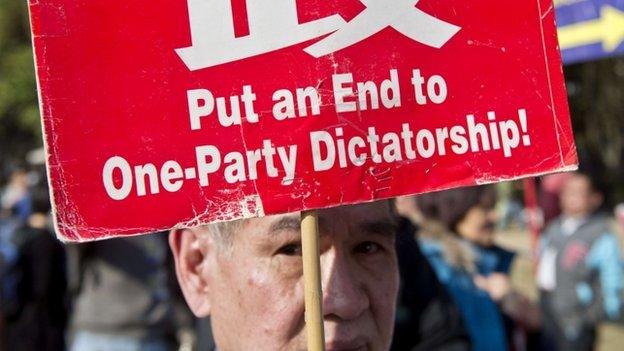 A protester holds a banner during a pro-democracy demonstration in Hong Kong on 1 January 2014. Tens of thousands of people rallied in Hong Kong to call for universal suffrage, as the city grapples with how its future leaders will be chosen under a long-awaited political reform