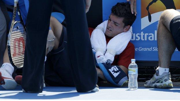 Frank Dancevic of Canada lies on the court after collapsing during his first round match against Benoit Paire of France