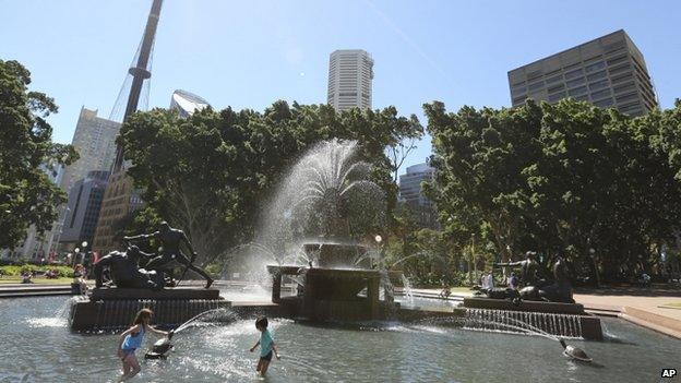 Children dip in a fountain to cool off in the hot weather in the central business district of Sydney, Australia, 15 January 2014