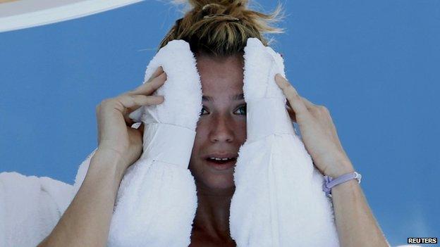 Camila Giorgi of Italy holds an ice towel to her face during her women's singles match against Alize Cornet of France at the Australian Open 2014 tennis tournament in Melbourne, 16 January 2014