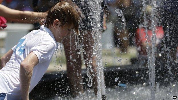 A boy plays in the fountain in the scorching heat at the Australian Open tennis championship in Melbourne, Australia, 16 January 2014