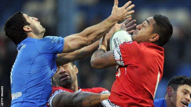 Tonga's Nesiasi Mataitonga (r) and Italy's Anthony Minichiello challenge for the ball