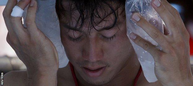 Japan's Kei Nishikori holds an ice pack to his face during his match against Dusan Lajovic of Serbia