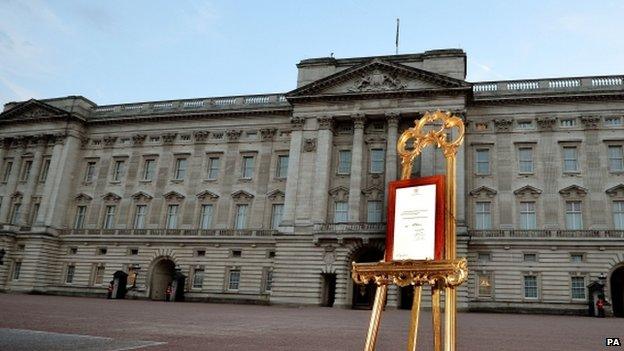 A notice announcing the birth of William and Catherine's baby on display in an ornate easel in the forecourt of Buckingham Palace