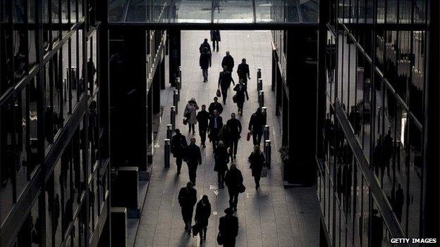 City workers walking past buildings in shadow