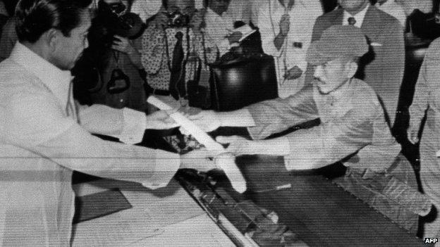 File photo: former Japanese imperial army soldier Hiroo Onoda (right) offering his military sword to former Philippine President Ferdinand Marcos (left) to express his surrender at the Malacanan Palace in Manila, Philippines, 11 March 1974