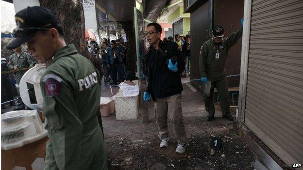 A Thai bomb squad unit examine the site of a blast at Victory monument in Bangkok on January 19