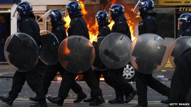 LONDON, ENGLAND - AUGUST 08: Riot police walk along Clarence Road in Hackney on August 8, 2011 in London, England