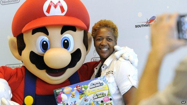 A woman stood with Super Mario and a Nintendo console