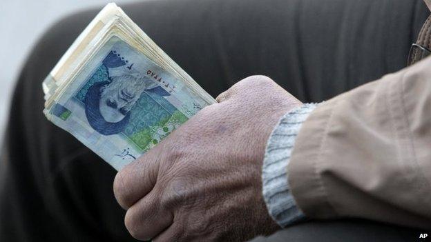 Man holds Iranian rials at Tehran's main bazaar (23 September 2013)