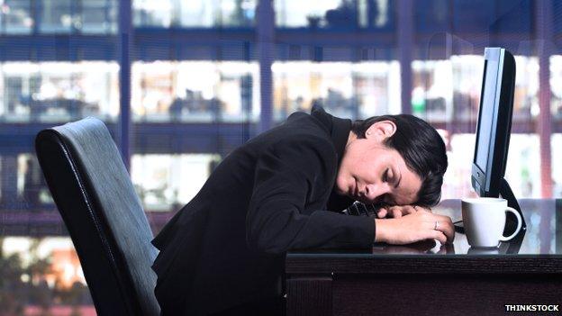 Woman at desk asleep at night