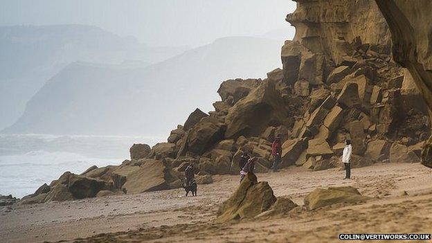 A family playing close to the rock fall on Hive Beach