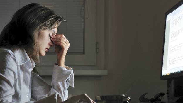 woman at desk with eyes closed