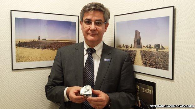 Denoix de Saint Marc in his office, holding a belt buckle