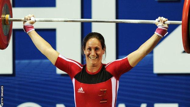 Michaela Breeze smiling as he lifts weights over her head