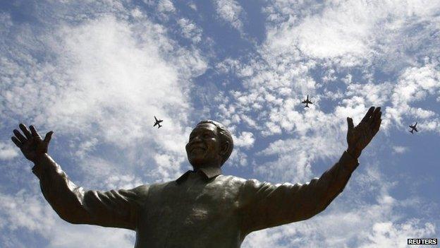 South African military jet fighters fly past a nine-metre (30ft) bronze statue of the late former South African President Nelson Mandela