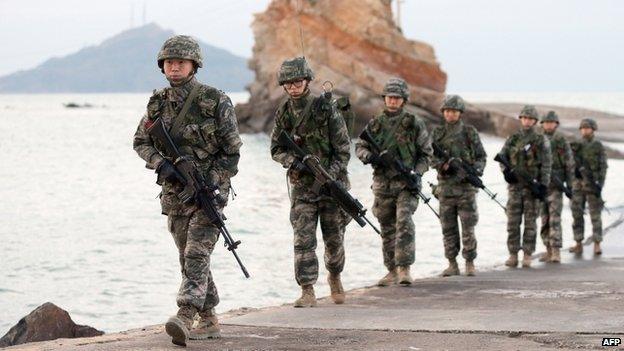 South Korean soldiers patrol on the South-controlled island of Yeonpyeong near the disputed waters of the Yellow Sea at dawn on 21 November 2013