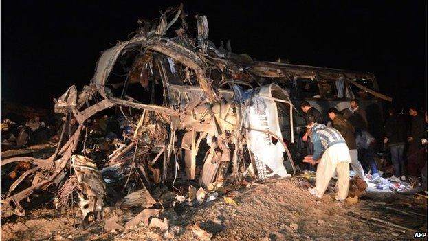 Pakistani Shia Muslims search the wreckage of a destroyed bus after a bomb attack 60 kilometres west of Quetta in Baluchistan on 21 January.