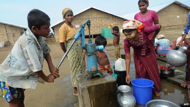 Rohingya people collect water from a well near their barracks at Bawdupah's Internally Displaced People camp on the outskirts of Sittwe, Burma, 18 May 2013