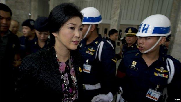 Thai Prime Minister Yingluck Shinawatra (C) leaves the Royal Thai Air Force building in Bangkok on 23 January 2014