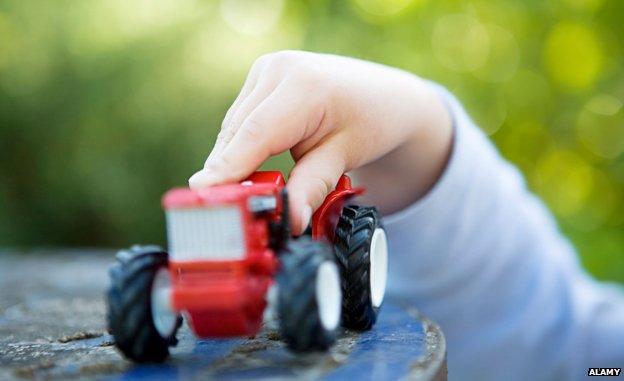 Child's and holding toy tractor