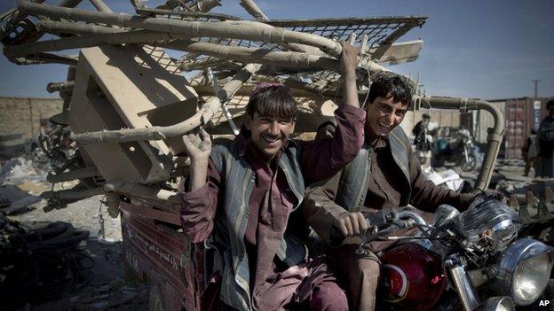 Afghan scrap collectors transport a load of destroyed US equipment from the departing military in Kandahar