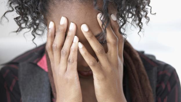 A woman holding her head in her hands