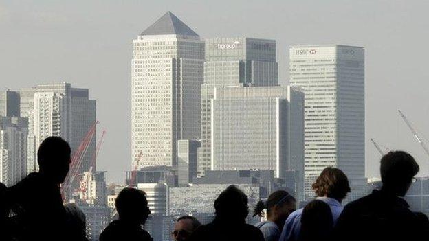 City workers silhouetted in front of the Canary Wharf skyline, financial centre, London