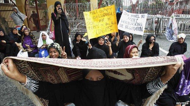 Filipino Muslim women hold placards during a rally urging the government to hold a round of peace talks with the MILF outside the Presidential Palace in Manila (June 28, 2013)