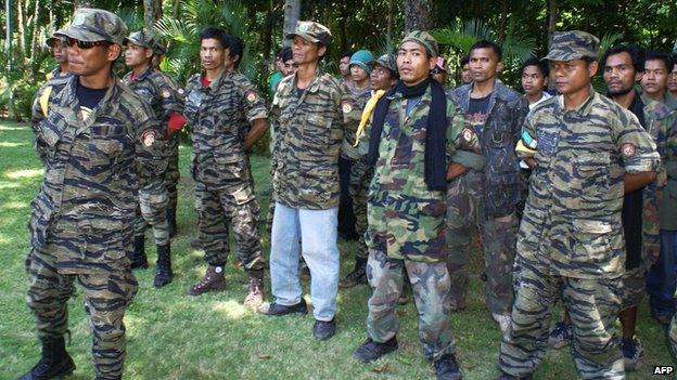 Thirty Muslim rebels from the Moro Islamic Liberation Front (MILF) led by Alvin Conto (Left) surrender to Philippine Army officers and Iligan City officials at the 104th Infantry Brigade Philippine Army base in Iligan city on August 21, 2008