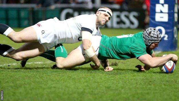 Isaac Boss scores an early try for Ireland despite the tackle of England's Charlie Sharples