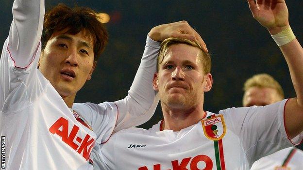 Ji Dong-Won, left, celebrates scoring FC Augsburg's equaliser at Borussia Dortmund.