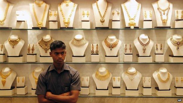 An Indian salesman stands by a counter at a gold jewelery shop in Mumbai